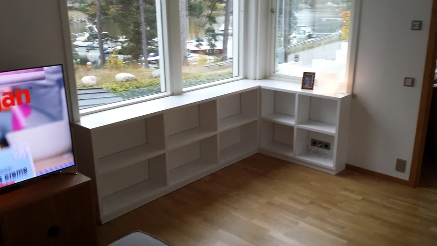 Låga hyllor längs fönsterväggen